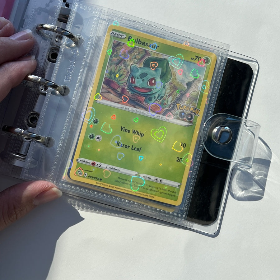 Pokémon card in a holographic heart sleeve inside a Meowcafe binder page